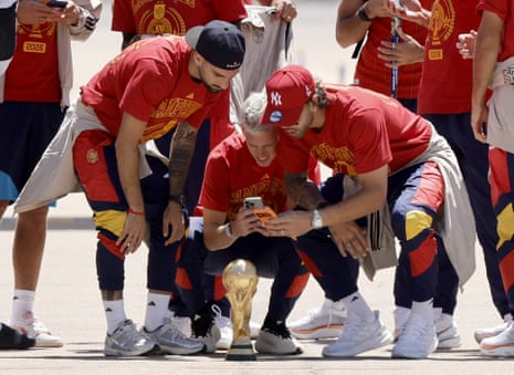 ESPANHA-FBL-WC-2026-CELEBRAÇÕESO atacante espanhol nº 10 Daniel Olmo (C) e o goleiro espanhol David Raya (R) tiram fotos de seu troféu na pista ao chegarem dos EUA após vencer a Copa do Mundo de 2026, no aeroporto de Madrid Barajas, em 20 de julho de 2026. Os vencedores da Copa do Mundo da Espanha voltam para casa para uma recepção de heróis em Madri, onde um milhão de torcedores são esperados para cumprimentá-los após uma noite de celebrações estridentes em todo o país. (Foto de Oscar DEL POZO / AFP via Getty Images)