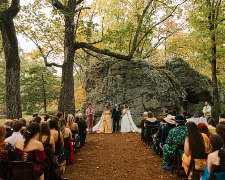 people sit in rows watching wedding outside