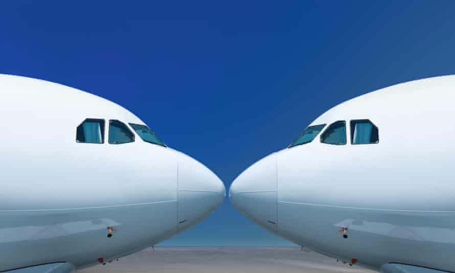 The noses of two white planes facing each other against a blue background