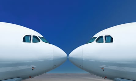 The noses of two white planes facing each other against a blue background