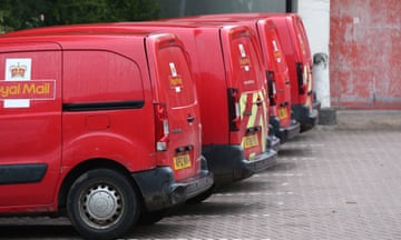 Four red Royal Mail vans in a car park