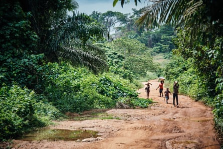 Cameroonian children walk along a dirt track