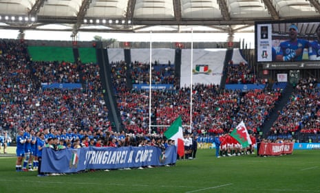 Los equipos se alinean en el campo mientras los jugadores italianos entonan sus himnos nacionales.