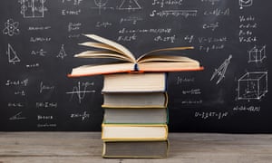 Books on the desk in the auditorium, formulas on the blackboard