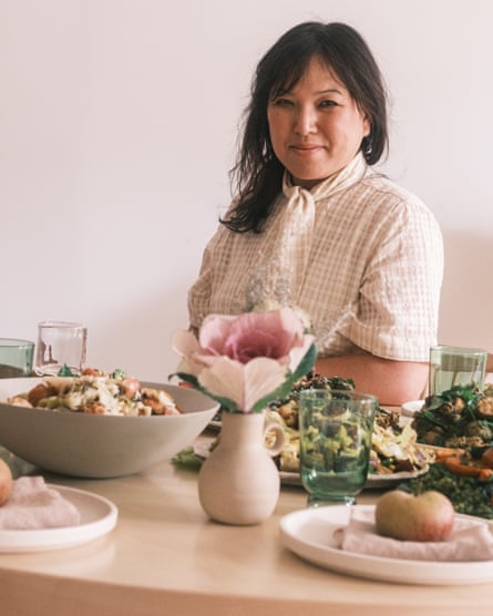 A portrait of Hetty Lui McKinnon sitting at a table with lots of food