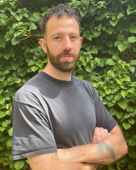 A man in a grey T-shirt with his arms crossed