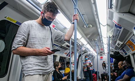 A man on the tube wearing a mask