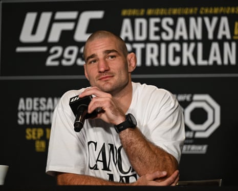 UFC fighter Sean Strickland holds a microphone to his chin at a press conference