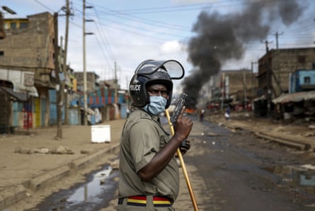 An armed police officer during clashes with protesters near a barricade in the Kariobangi slum of Nairobi