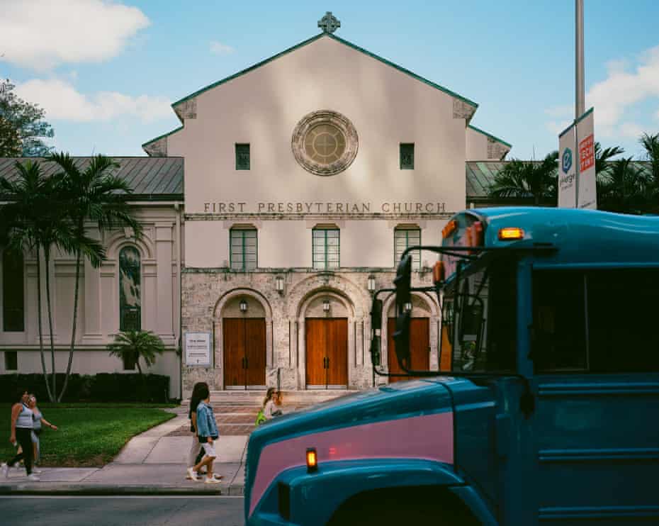 Pedestrians walk past a church.