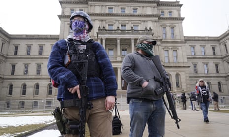 Two demonstrators with rifles standing outside the state Capitol in Lansing, Michigan, today.