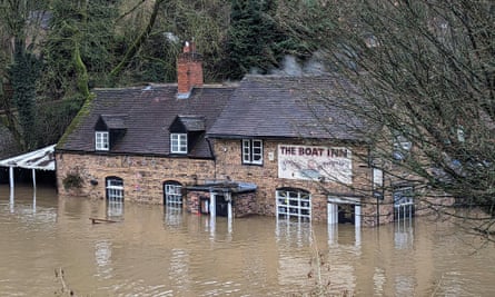The Boat Inn pub stands in floodwaters, half submerging the windows and doors on the ground floor.