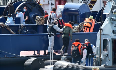 UK Border Force officers help migrants to disembark from a coastal patrol vessel in Dover on 9 August.
