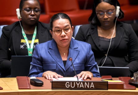Carolyn Rodrigues-Birkett behind a microphone at a table with a sign saying ‘Guyana’