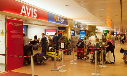 Holidaymakers queue at car rental desks at Malaga airport.
