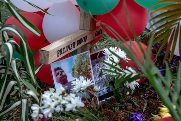 Photos and balloons adorn the grave of Breiner David Cucuñame