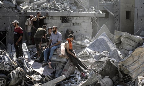 Palestinians sit in the rubble of a residential building levelled in an Israeli airstrike as they search for victims and survivors in the Khan Younis refugee camp in the southern Gaza Strip.