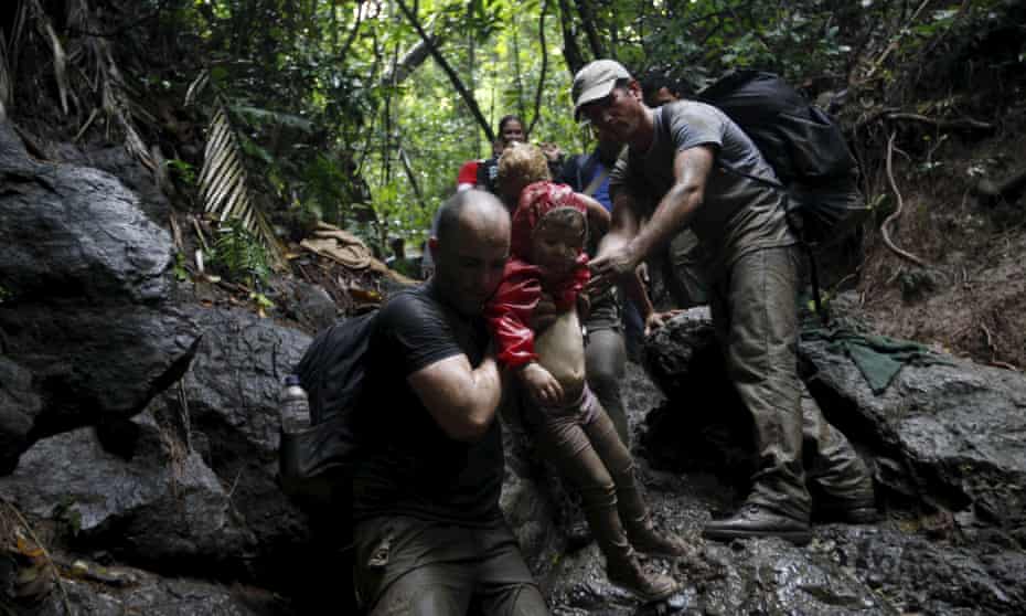 Cuban migrants help to carry a child as they climb down a slope crossing the border from Colombia through the jungle into La Miel, in the province of Guna Yala, Panama, last year.