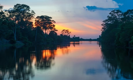 The sun sets along the banks of the Amazon river.