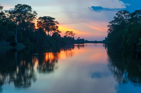 The sun sets along the banks of the Amazon river.