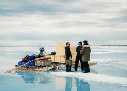 Three people stand in an expanse of ice