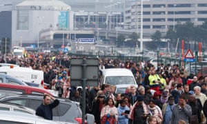 Passengers and airport staff are evacuated from the terminal building after Tuesday morning’s explosions.