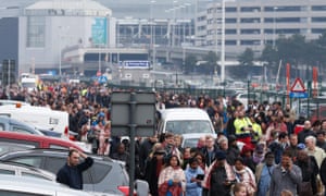 Passengers and airport staff are evacuated from the terminal building after Tuesday morning’s explosions.