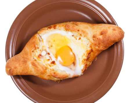 A pastry filled with cheese and topped with a soft-boiled egg and butter
