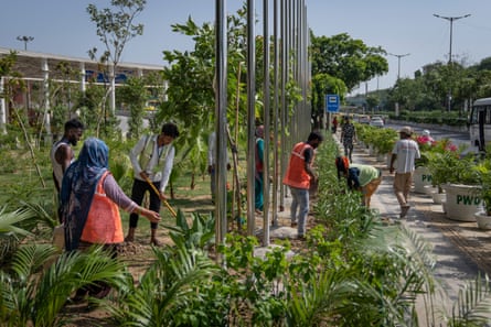 Municipality workers prepare the sidewalk outside the main venue for the G20 Summit in Delhi.