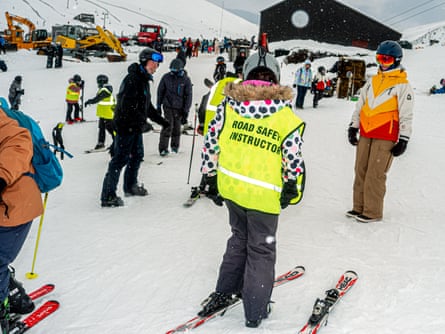Skiers, one with hi-vis jacket saying Road Safety Instructor