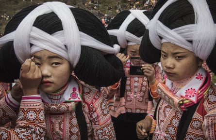 A teenage girl from the Long Horn Miao ethnic group has makeup applied as she and her friends prepare to celebrate tiaohua (flower) festival. The event is part of lunar new year festivities in Longga village, Guizhou province, southern China