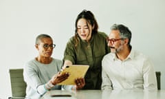 Medium shot colleagues looking at data on digital tablet during meeting<br>Medium shot of business colleagues looking at data on digital tablet during meeting in office conference room