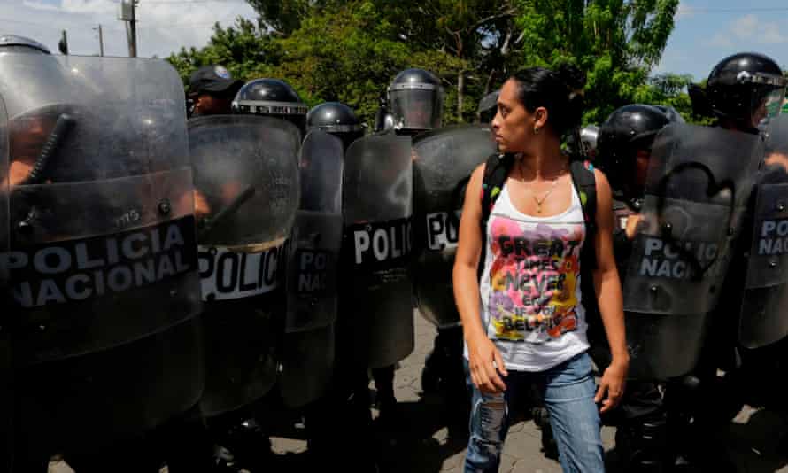 A woman confronts riot police blocking a street during a protest against Daniel Ortega’s government in Managua