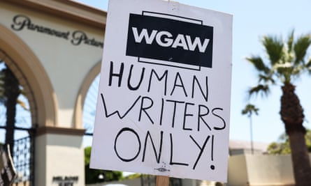 A Writers Guide America placard … AI has also been an issue in their dispute.