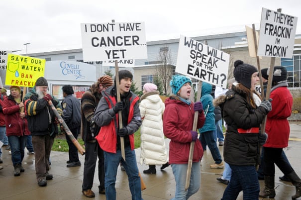Anti-fracking protestors carry signs while protesting in front of The Covelli Center near downtown Youngstown, Ohio, where the Youngstown Ohio Utica & Natural Gas Conference & Expo took place.