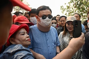 The former prime minister Thaksin Shinawatra is photographed with a supporter next to his daughter Paetongtarn Shinawatra as they visit the Royal Park Rajapruek