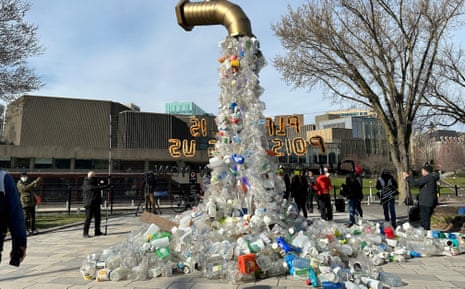 A prop depicting a water tap with cascading plastic bottles is displayed by activists near the Shaw Centre in Ottawa,