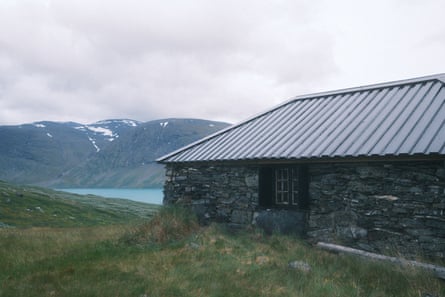 A small brick, one storey building with a lake in the background A small brick, one storey building with a lake in the background