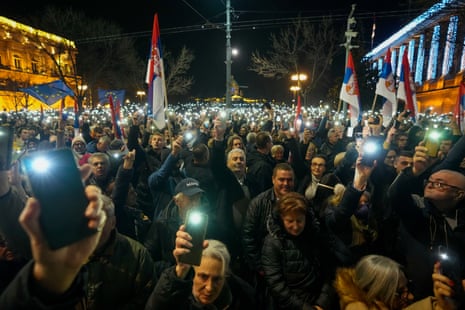 Serbian opposition supporters hold up lights during a protest outside the electoral commission building in Belgrade, Serbia