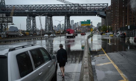 A motorist stands by his broken-down car in floodwater on the FDR highway in Manhattan, New York on 29 September 2023. 