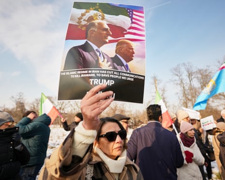 A member of the Iranian community holds a poster of Iran's exiled crown prince, Reza Pahlavi, and Donald Trump outside the US embassy in Bucharest, Romania.