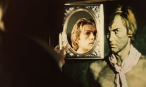Helmut Berger as Dorian Gray, holding a mirror and seeing a younger man