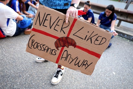 An England fan holds a banner which reads “Never Liked Croissants Anyway” prior to the game.