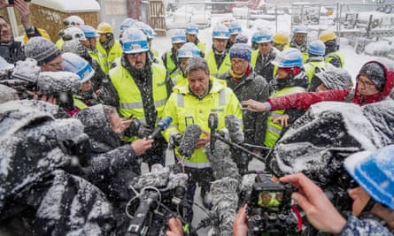 Members of the media surround a German minister