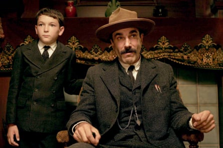 a man in a hat sitting in a chair as a younger boy stands next to him