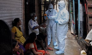 A healthcare worker checks the body temperature of a man in Dharavi, Asia’s largest slum colony, last month.