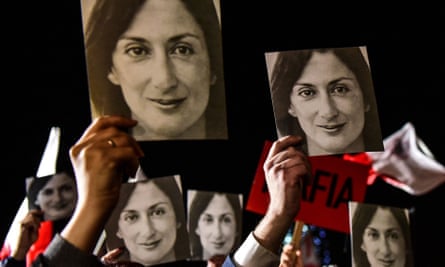 People holding placards reading ‘Mafia Government’ and photos of Daphne Caruana Galizia during a protest called by her family and civic movements outside the office of the prime minister in Valletta, Malta in 2019.