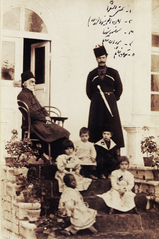 Shams al-Sho’ara (Abdulhossein Mirza Shams Molkara), seated, his son-in-law Amanullah Mirza Jahanbani (1869-1912) standing on the right, small boy wearing a hat (Mansour Mirza Jahanbani), other boy Azizollah, two little girls (Pouran Khanom Jahanbani, Touran Khanom Jahanbani), and an African slave girl, 1900s.