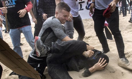A man slamming another man's head in the sand
