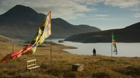 From Akomfrah’s 2023 installation Arcadia. A figure, a flag, lake and moutains.